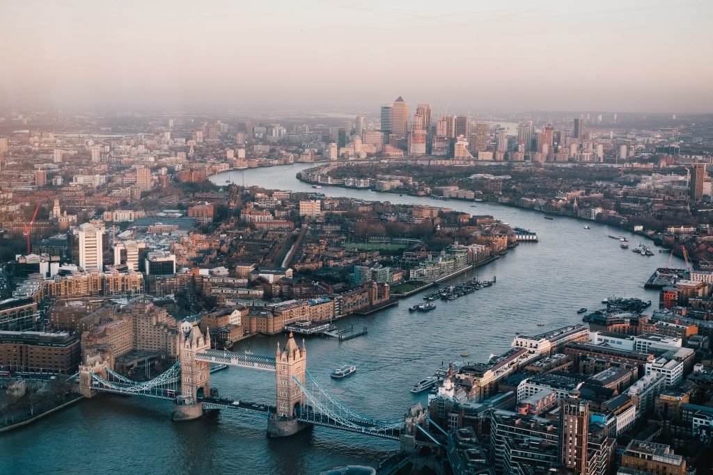 Ariel shot of London showing the River Thames, Tower Bridge and in the background Canary Wharf.