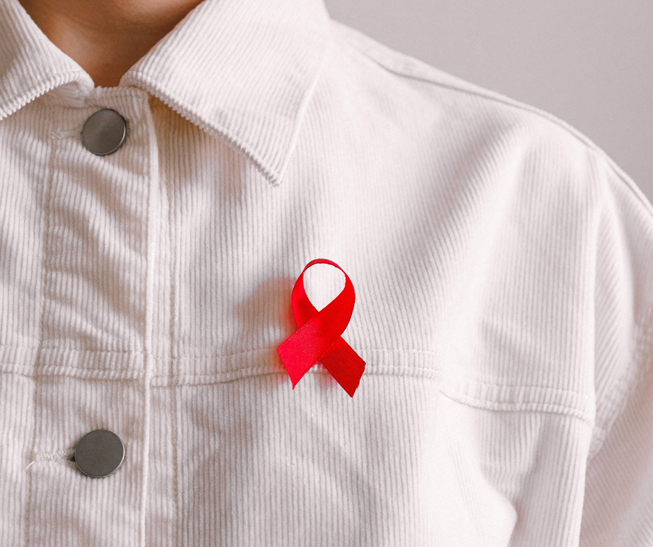 Photo of a person wearing a white jacket with the HIV awareness red ribbon