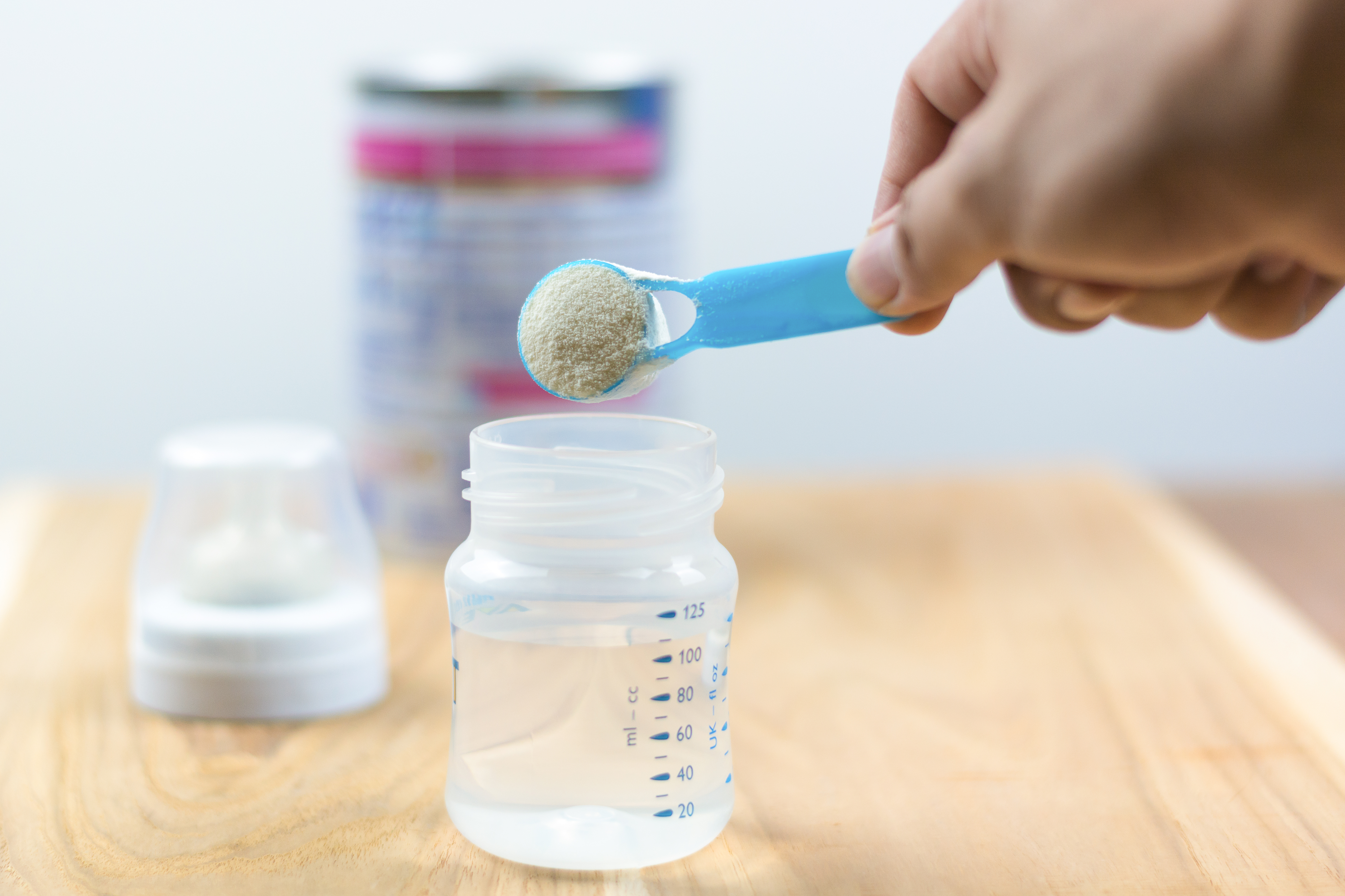 Infant formula milk using a measuring spoon Powdered milk with a spoon for babies Infant formula and bottle